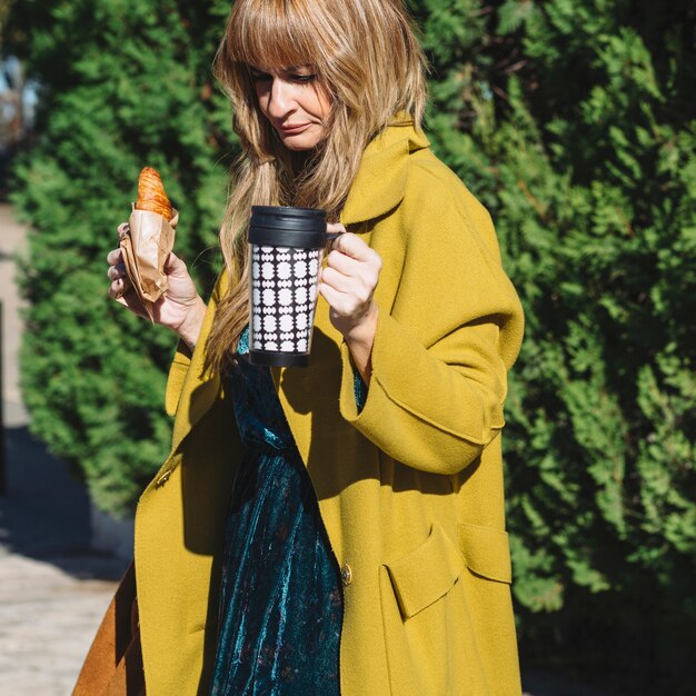 Mujer con termo y croissant