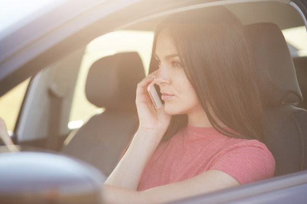 La mujer tiene una conversación telefónica a través del teléfono móvil moderno