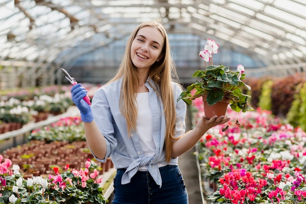 Foto gratuita mujer con tijera de jardinería cuidando flores