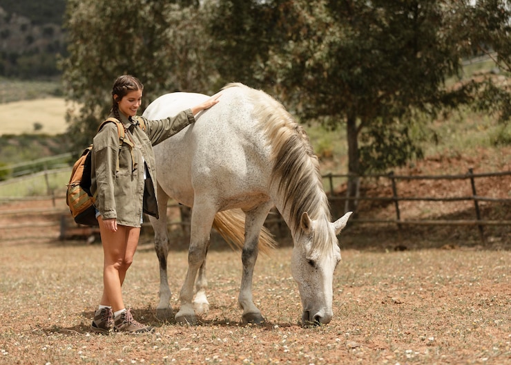 Foto gratuito mujer de tiro completo acariciando a caballo