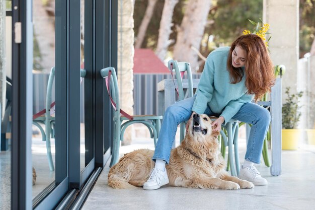 Mujer de tiro completo acariciando perro feliz