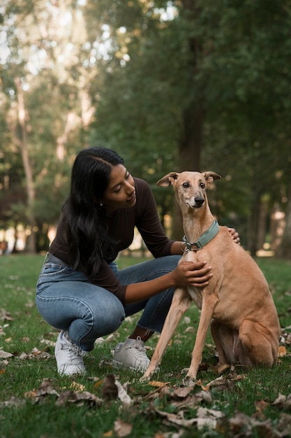 Foto gratuita mujer de tiro completo acariciar a perro