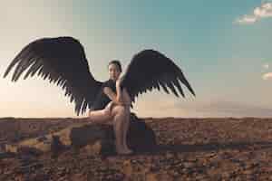 Foto gratuita mujer de tiro completo con alas al aire libre