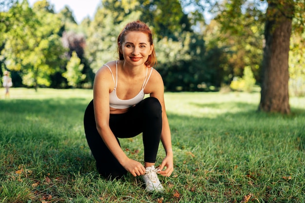 Mujer de tiro completo atando sus cordones