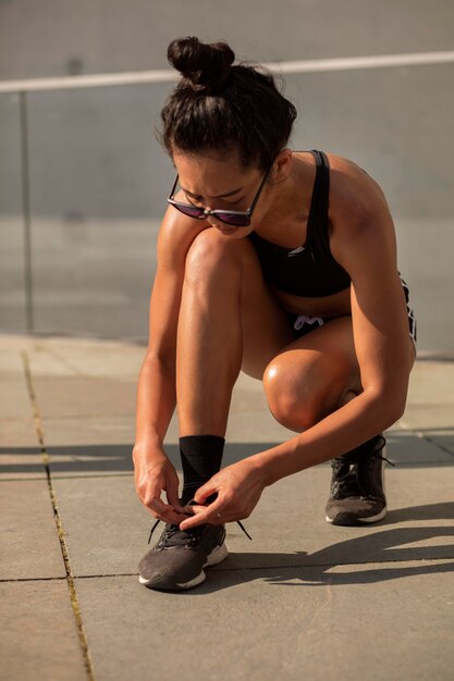 Mujer de tiro completo atando sus zapatos