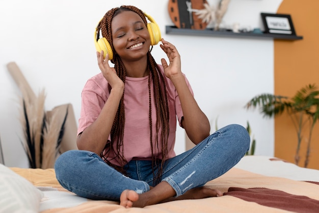 Mujer de tiro completo con auriculares amarillos