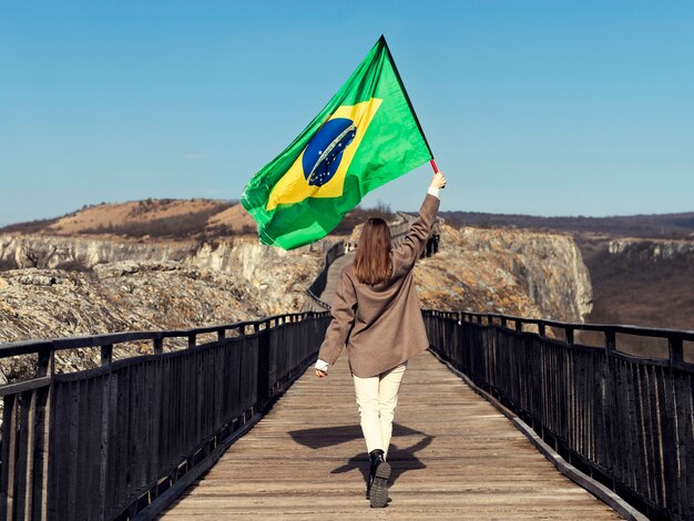 Mujer de tiro completo con bandera brasileña