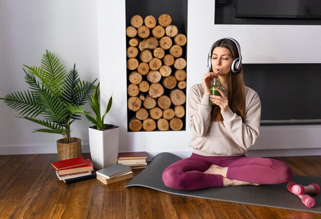 Mujer de tiro completo bebiendo batido