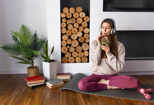 Mujer de tiro completo bebiendo batido