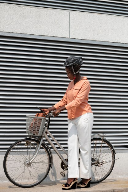 Mujer de tiro completo con bicicleta y casco.