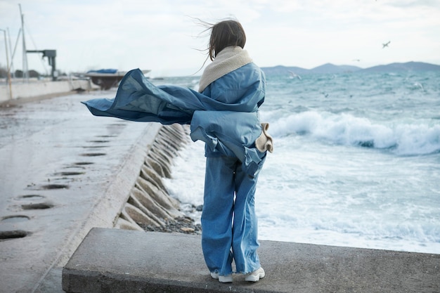 Foto gratuita mujer de tiro completo con bufanda cálida en la playa