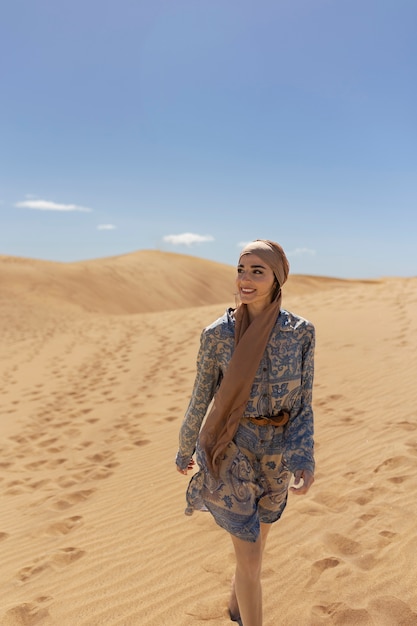 Mujer de tiro completo con bufanda en el desierto