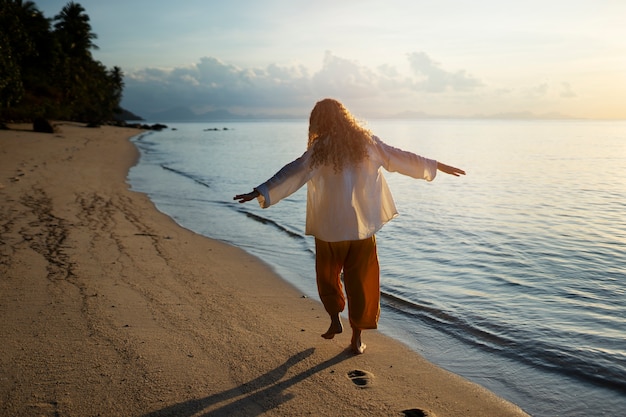 Foto gratuita mujer de tiro completo caminando en la playa