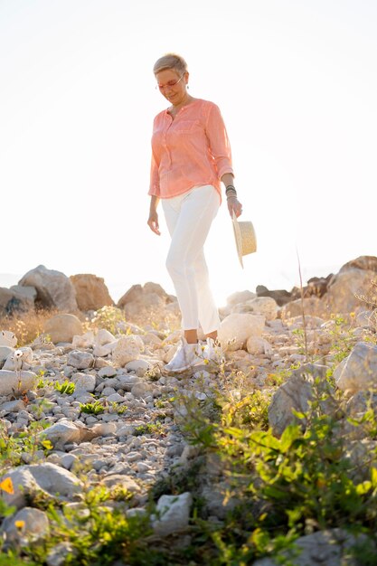 Mujer de tiro completo caminando sobre rocas