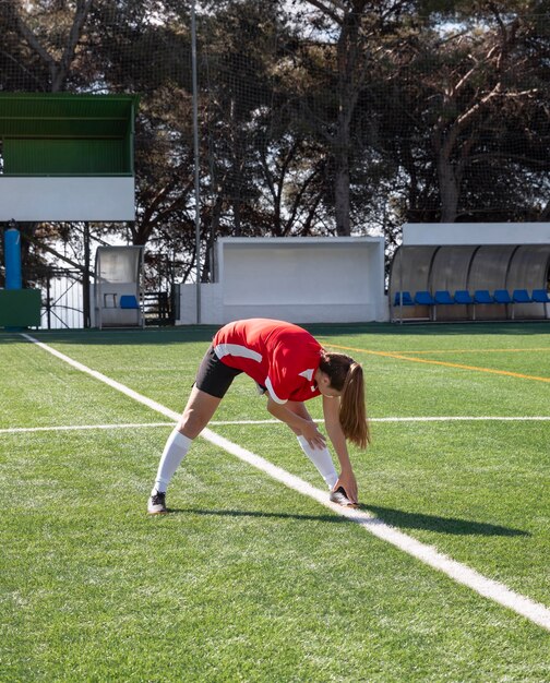 Mujer de tiro completo en el campo de fútbol