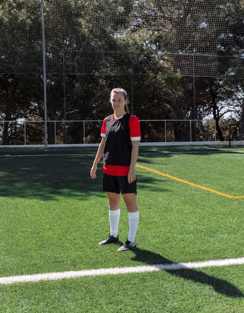 Mujer de tiro completo en el campo de fútbol