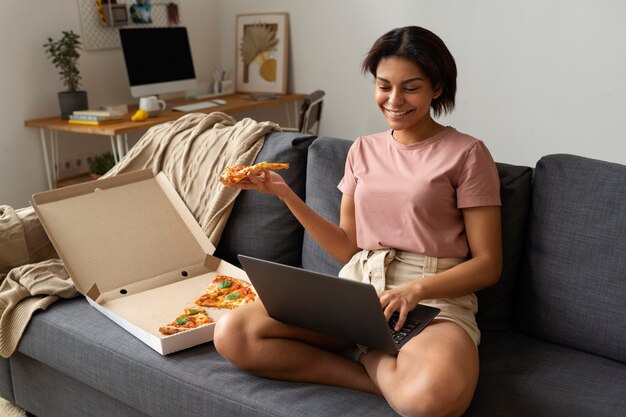 Mujer de tiro completo comiendo deliciosa pizza