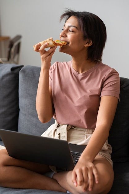 Mujer de tiro completo comiendo deliciosa pizza