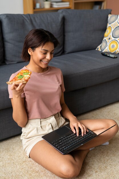 Mujer de tiro completo comiendo deliciosa pizza