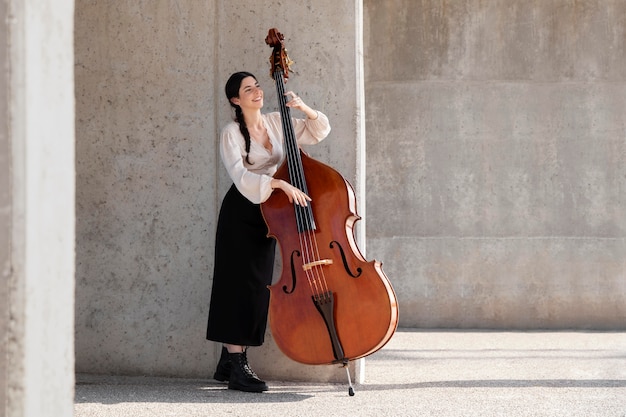 Mujer de tiro completo con contrabajo