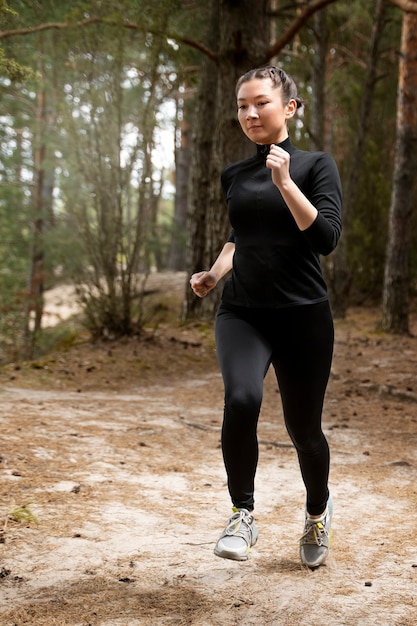 Mujer de tiro completo corriendo al aire libre