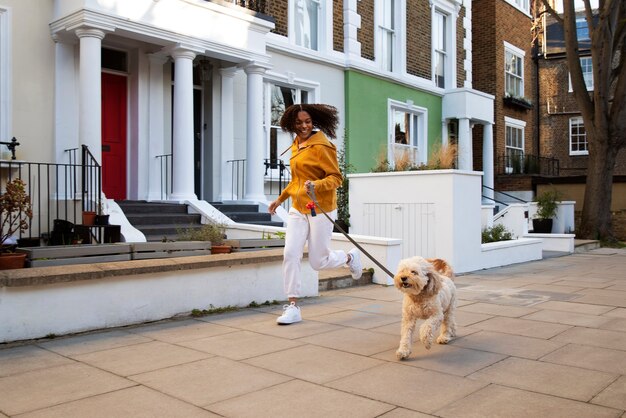 Mujer de tiro completo corriendo con perro al aire libre