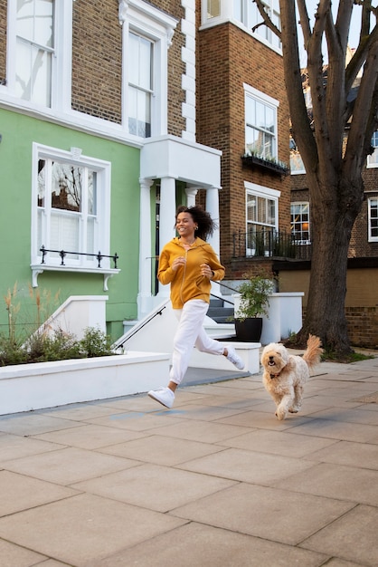 Mujer de tiro completo corriendo con perro al aire libre