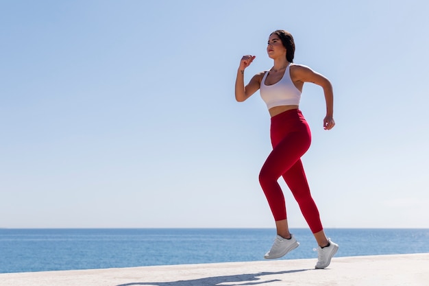 Foto gratuita mujer de tiro completo corriendo en la playa