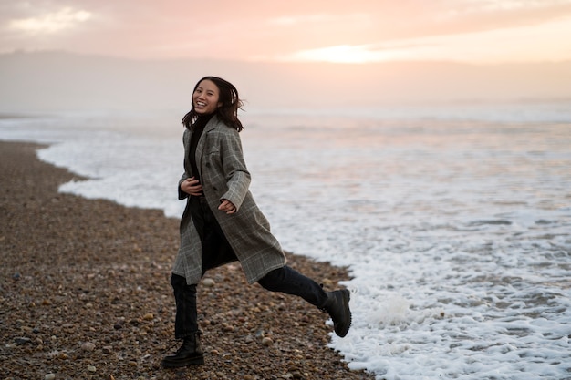 Foto gratuita mujer de tiro completo corriendo en la playa