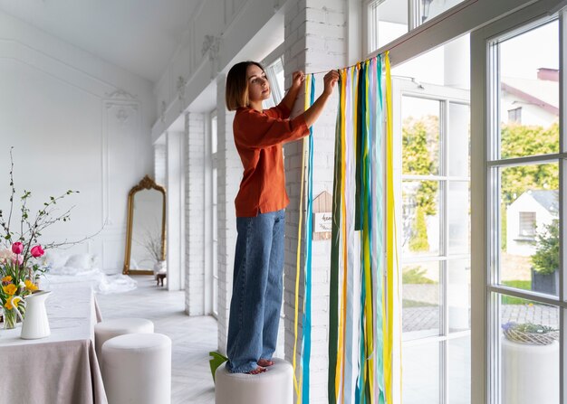 Mujer de tiro completo decorando la puerta de entrada