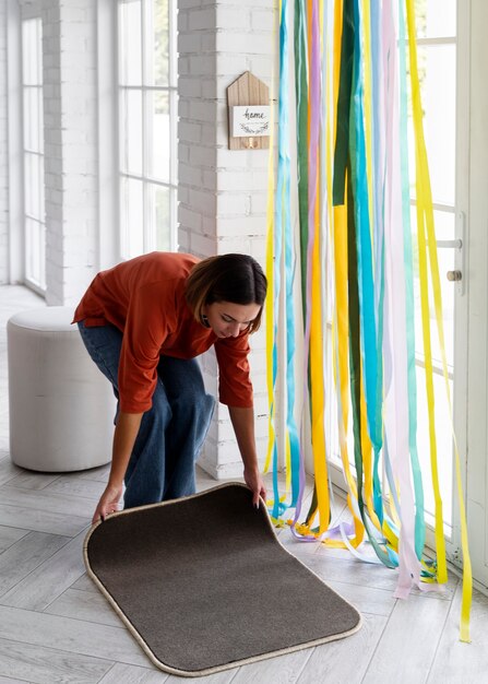 Mujer de tiro completo decorando la puerta de entrada