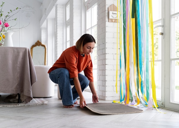 Mujer de tiro completo decorando la puerta de entrada