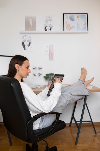 Mujer de tiro completo dibujando en el ipad.