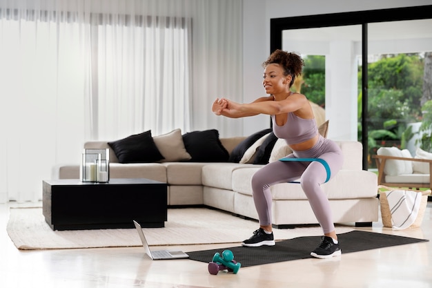 Mujer de tiro completo entrenando con banda elástica