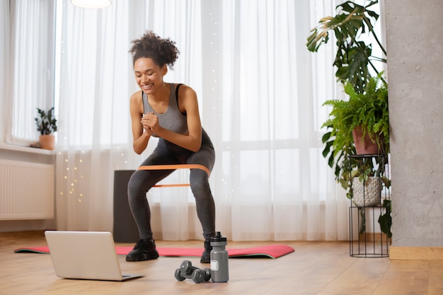 Mujer de tiro completo entrenando con banda elástica.