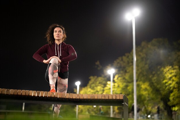 Mujer de tiro completo entrenando por la noche