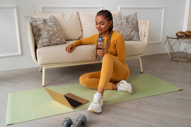 Mujer de tiro completo entrenando con portátil