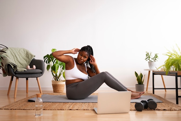 Foto gratuita mujer de tiro completo entrenando con portátil