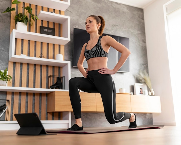 Mujer de tiro completo entrenando con tableta