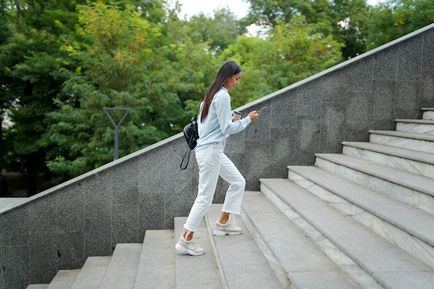 Mujer de tiro completo en las escaleras