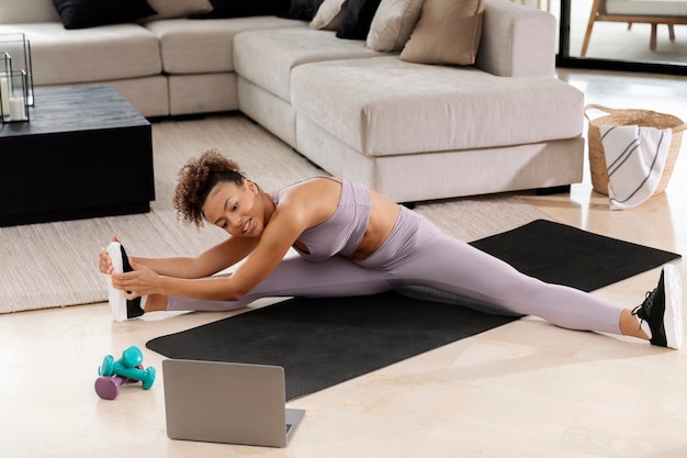 Mujer de tiro completo en estera de yoga