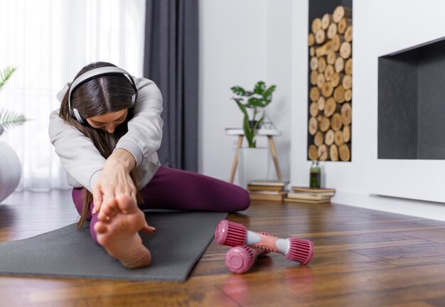 Mujer de tiro completo estirando la pierna