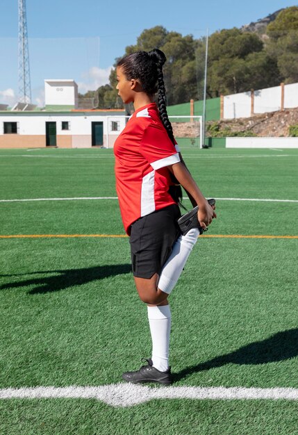 Mujer de tiro completo estirando la pierna