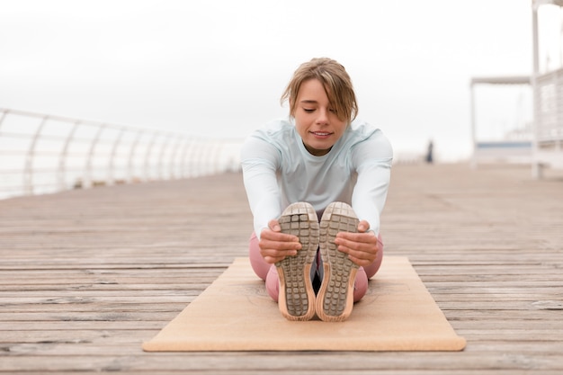 Mujer de tiro completo estirando las piernas