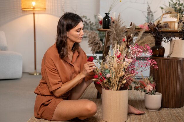 Mujer de tiro completo con flores secas.