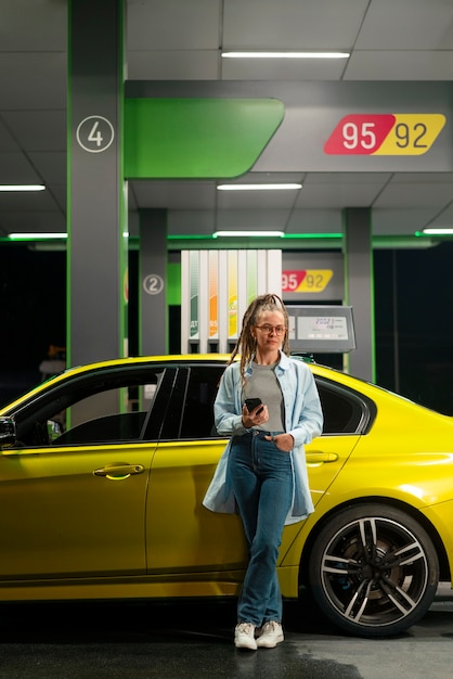 Foto gratuita mujer de tiro completo en la gasolinera