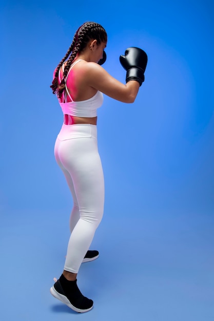 Mujer de tiro completo con guantes de boxeo