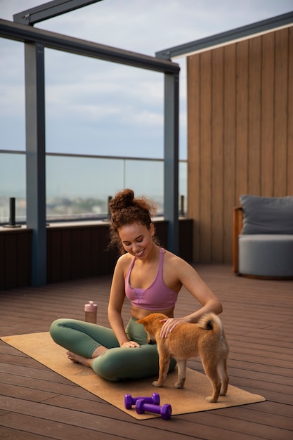 Foto gratuita mujer de tiro completo haciendo deporte acompañada de perro.