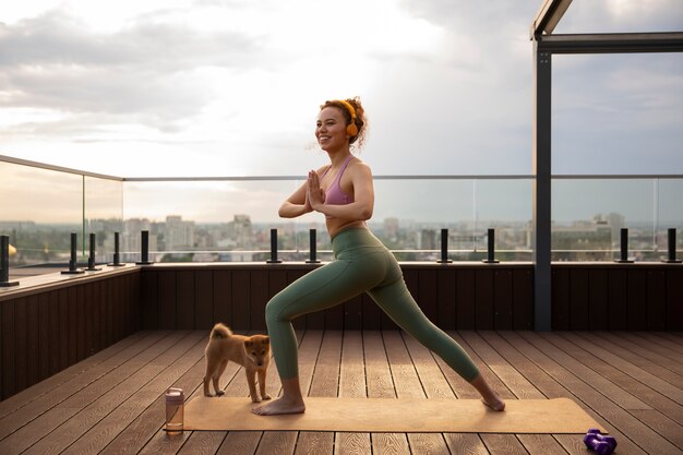 Mujer de tiro completo haciendo deporte acompañada de perro.