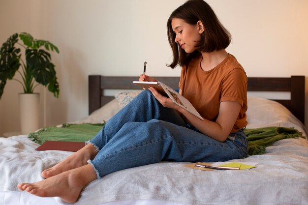 Mujer de tiro completo haciendo un diario creativo